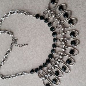 Bib necklace with emerald color gems